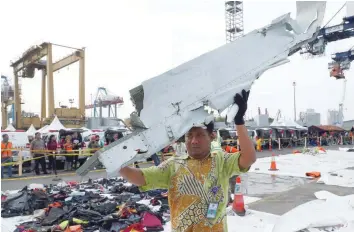  ?? — Reuters ?? Workers load up recovered debris and belongings believed to be from Lion Air flight JT610 onto a truck at Tanjung Priok port in Jakarta on Friday.