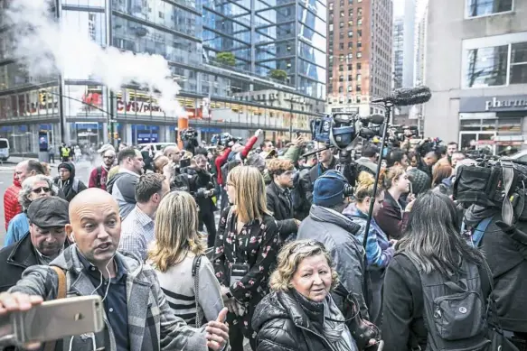  ?? Jeenah Moon/The New York Times ?? Pedestrian­s and members of the news media gather near the Time Warner Center in New York on Wednesday shortly after the building was evacuated. Explosive devices were sent to former President Barack Obama and former Secretary of State Hillary Clinton, as well as to CNN’s offices in New York.