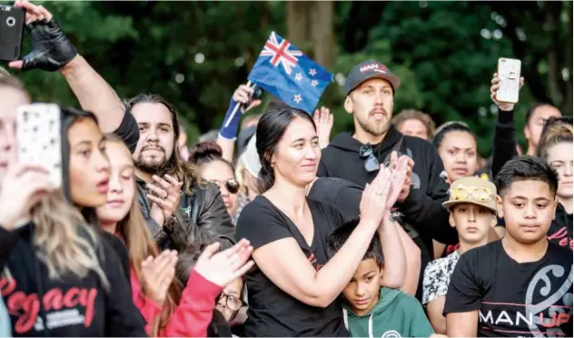  ?? Agence France-presse ?? ↑ People applaud after biker gangs performed the haka as a tribute to victims in Christchur­ch on Wednesday.