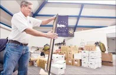  ?? BRAD HORRIGAN/HARTFORD COURANT ?? Greater Middletown Military Museum curator Ken McClellan unpacks and catalogues a World War I-era service roster from the Middletown Council of the Knights of Columbus. These and other donations need to be examined and catalogued by McClellan.