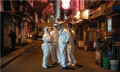  ?? ?? Government workers in protective gear on a Hong Kong street this year. The city is experienci­ng its worst Covid surge and has a death rate among the highest in the world. Photograph: Anthony Kwan/Getty Images