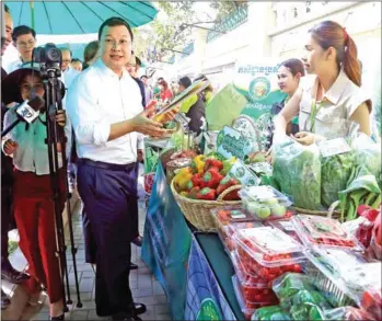 ?? HENG CHIVOAN ?? Agricultur­e minister Dith Tina visits the ministry’s organic vegetable sale on Valentine’s Day.