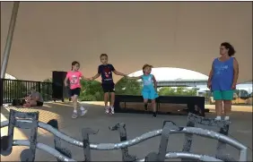  ??  ?? From right, Irish dancer Becky Katricak controls the music as beginning Irish dancers Ava Cox, 6, Daniel Smith, 8, and Maura Smith, 5, all of Lorain, work on their steps with teacher Heather Long on Sept. 14under the stage canopy at Black River Landing in Lorain.