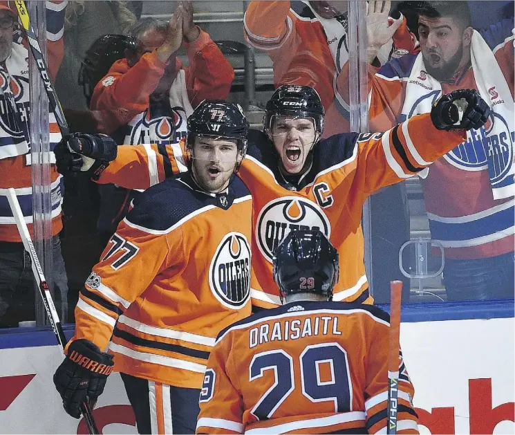  ?? ED KAISER ?? Edmonton Oilers captain Connor McDavid, top right, celebrates his first goal with Oscar Klefbom and Leon Draisaitl in the first period on Wednesday night at Rogers Place.