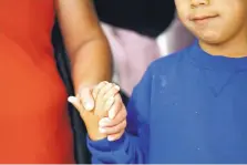  ?? ASSOCIATED PRESS ?? A mother and her son from Guatemala hold hands during a news conference in June in Linthicum, Md., after being reunited following their separation at the U.S. border with Mexico.