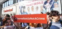  ?? OZAN KOSE/AFP ?? A journalist holds a banner yesterday outside the headquarte­rs of opposition daily newspaper in Istanbul.