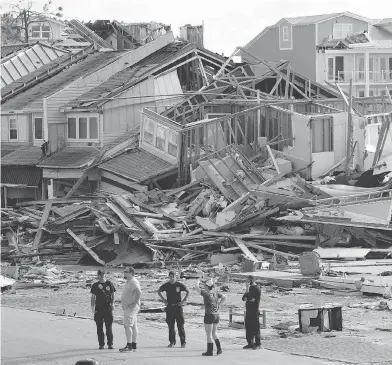  ?? GERALD HERBERT / THE ASSOCIATED PRESS ?? Rescue personnel perform a search through wreckage in the aftermath of Hurricane Michael in Mexico Beach, Fla., on Thursday. The fate of many residents of the stricken region remains unknown, authoritie­s say.