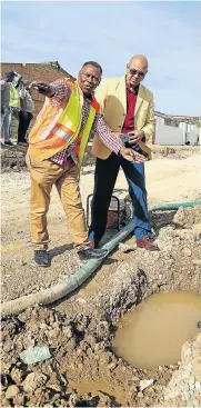  ?? Picture: WERNER HILLS ?? FOUL FLOW: Infrastruc­ture head Walter Shaidi, left, and councillor Marlon Daniels in Zwide, where a leaking sewerage pipe has prevented access to residents’ driveways