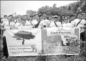  ??  ?? OFI employee volunteers during a tree-planting activity.