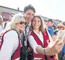  ?? JEFF BASSETT/THE CANADIAN PRESS ?? Prime Minister Justin Trudeau poses for a selfie with Canadian Red Cross workers at event stop in Revelstoke, B.C., on Saturday.