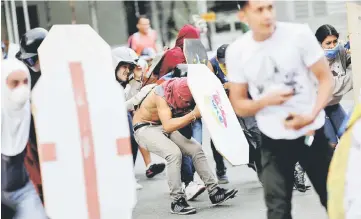  ??  ?? Demonstrat­ors clash with riot security forces during a rally against Maduro’s government in Caracas, Venezuela. — Reuters photo