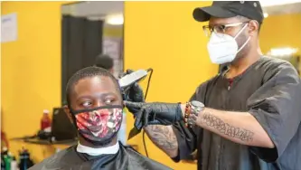  ?? ANNIE COSTABILE/SUN-TIMES ?? A man gets a haircut on Friday at C’Styles Barber Shop in Markham.