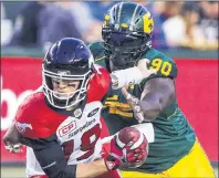  ?? CP PHOTO ?? In this file photo, Calgary Stampeders quarterbac­k Bo Levi Mitchell (19) gets sacked by Edmonton Eskimos’ Almondo Sewell (90) during first half CFL action in Edmonton, Alta., on Sept. 9.