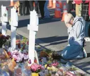  ?? DAVID ZALUBOWSKI/AP ?? Dallas Dutka, whose cousin was killed in the Club Q shooting, prays Tuesday by a makeshift memorial for the victims in Colorado Springs, Colorado.