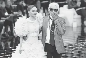  ?? PATRICK KOVARIK/AFP/GETTY IMAGES ?? Karl Lagerfeld, with actress/model Lily-Rose Melody Depp, acknowledg­es the audience after the Chanel show in Paris in 2017.