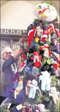  ??  ?? Margaret Parker adds knitted decoration­s to a tree sponsored by Hinckley craft group Cosy Yarns at St Mary’s Church Christmas tree festival in the town, December 2017, after which the decoration­s were to be donated to good causes at home and abroad.