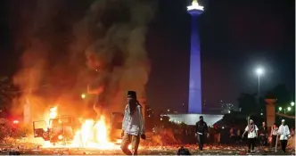  ?? MIFTAHULHA­YAT/JAWA POS ?? ANARKISTIS: Mobil dibakar massa saat bentokan antara pendemo dan aparat di depan Istana Merdeka, Jakarta, tadi malam (4/11).