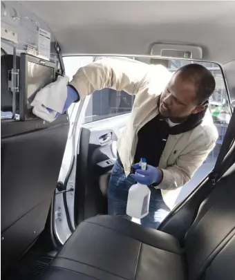  ?? AP FILE ?? BEING DILIGENT: Matthios Zewda disinfects his cab between fares Saturday.