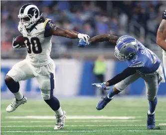  ?? REY DEL RIO THE ASSOCIATED PRESS ?? Los Angeles Rams running back Todd Gurley, left, pushes Lions’ Darius Slay in the first half Sunday in Detroit. Gurley rushed for 132 yards and two touchdowns in a 30-16 win that pushed the team to 11-1 on the season.