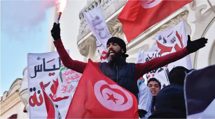  ?? Gareth Browne / The National; Reuters ?? Above and below, hundreds march against austerity in the Tunisian capital Tunis on the seventh anniversar­y of the Jasmine Revolution yesterday