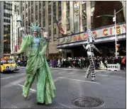  ??  ?? Dressed as the Statue of Liberty, Maria Kent, left, makes her way down Sixth Avenue during the parade.