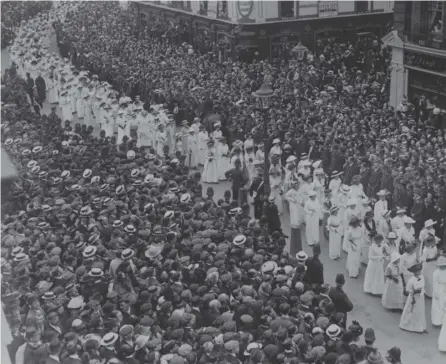  ??  ?? 0 Crowds watch the funeral procession of Suffragett­e Emily Davison, who died after being trampled by the king’s horse