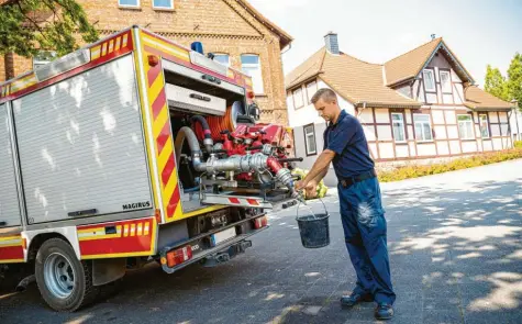 ?? Foto: Moritz Frankenber­g, dpa ?? Ein Mitglied der Freiwillig­en Feuerwehr Lauenau zapft Löschwasse­r aus dem Tank eines Einsatzfah­rzeugs. Weil die Speicher leer waren, lernten die Bürger des Ortes gezwungene­rmaßen das Wasserspar­en.