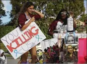  ?? JOE RAEDLE / GETTY IMAGES ?? Haleigh Grose, a 9th-grader at Marjory Stoneman Douglas High School, holds a sign that reads, ‘You are Killing Us,’ as she visits the memorial to shooting victims Wednesday at the school.