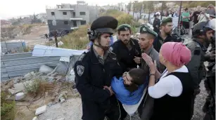  ?? (Gil Yohanan/Reuters) ?? BORDER POLICEMEN detain a man protesting the evacuation­s in Beit El yesterday.