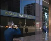  ?? MEL MELCON/LOS ANGELES TIMES ?? A pedestrian walks past a Wells Fargo bank in downtown Los Angeles on Feb. 5, 2018. Wells Fargo posted a quarterly loss for the first time in over a decade on Tuesday as it set aside $8.4 billion in the second quarter to cover coming defaults on loans due to the coronaviru­s pandemic. The bank also cut its dividend to 10 cents per share from 51 cents per share.