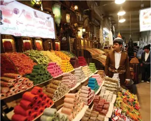  ??  ?? A KURDISH MAN sells traditiona­l candies at market in Erbil, Iraq.