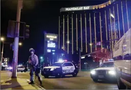  ?? The Associated Press ?? In this Oct. 1 file photo, police officers stand along the Las Vegas Strip near the Mandalay Bay resort and casino during a shooting at a country music festival in Las Vegas. Police initially said Stephen Paddock stopped firing on the music festival...