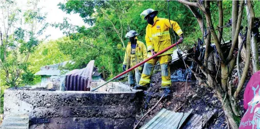  ??  ?? Firefighte­rs conduct cooling down operation at this house in Burnside Valley, Red Hills, St Andrew, yesterday.