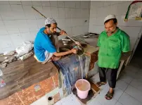  ?? MUHAMMAD SAJJAD / KHALEEJ TIMES ?? Muzammil Khan drains rain water from his tandoor instead of baking bread.