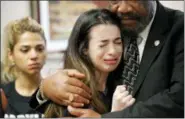  ?? GERALD HERBERT — ASSOCIATED PRESS ?? Aria Siccone, 14, a ninth-grader at Marjory Stoneman Douglas High School in Parkland, Fla., is consoled by Democratic state Rep. Barrinton Russell on Wednesday in Tallahasse­e, Fla.