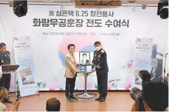  ?? Courtesy of Starkey Korea ?? Starkey Korea CEO Shim Sang-don, left, receives a certificat­e for an honorary Korean War Medal from Brigadier Gen. Woo Kyung-kwan, on behalf of his late father Shim Eun-taek at Starkey Korea Hall in Seoul, Wednesday.