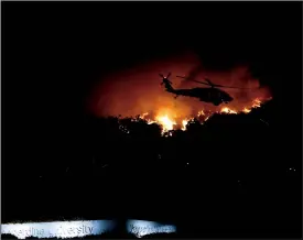  ?? TRIBUNE NEWS SERVICE FILE PHOTOGRAPH ?? A helicopter battle the Woolsey wild fire in the hills above Pepperdine University in Malibu, on Friday, Nov. 9, 2018.