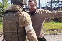  ?? SOURCE: RUSSIAN DEFENSE MINISTRY PRESS SERIVICE ?? This photo taken May 18 from video shows a Russian serviceman frisking a Ukrainian soldier after he left the besieged Azovstal steel plant in Mariupol.