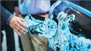  ?? BLOOMBERG ?? An attendee in Stuttgart, Germany, opens the fuel cap of an Mercedes-Benz SUV. The company will make the first battery that can be charged with both hydrogen and electricit­y this year.