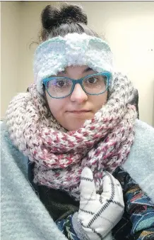  ?? REBECCA MILLER ?? Rebecca Miller, an academic adviser at Tennessee State University, wears sweaters, a scarf, ear coverings, gloves and a blanket over her lap while she works at her desk in Nashville.