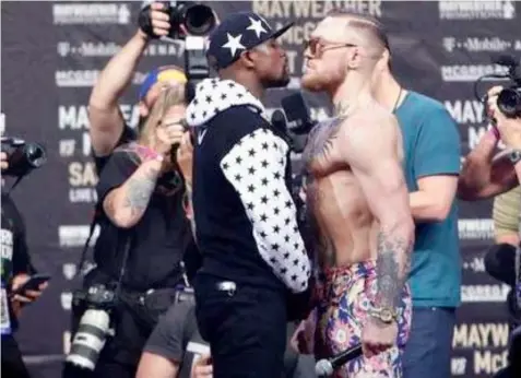  ?? (AP Photo/Frank Franklin II) ?? This July 13, 2017 photo shows Floyd Mayweather Jr., left, and Conor McGregor, of Ireland, facing each other for photos during a news conference at Barclays Center in New York. So far fans aren't exactly storming the box office to buy tickets for...