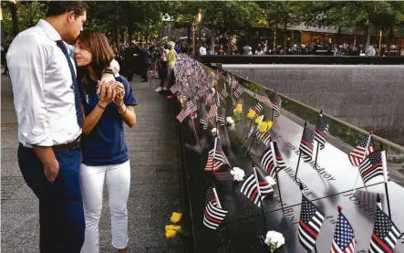  ?? Craig Ruttle / Getty Images ?? NEW YORK: Katie Mascali is comforted by her fiance, Andre Jabban, as they stand near the name of her father, Joseph Mascali.