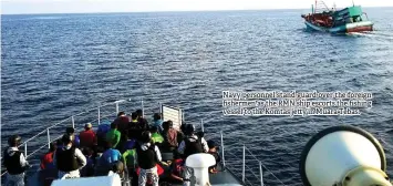  ??  ?? Navy personnel stand guard over the foreign fishermen as the RMN ship escorts the fishing vessel to the Komtas jetty in Muara Tebas.