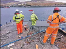  ??  ?? Concrete is delivered to the Ulva pier, left, and workers resurface the lower part of the slipway.