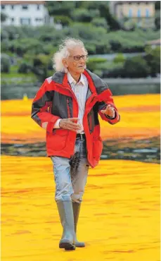  ?? FOTO: AFP ?? Christo bei einem Spaziergan­g auf seinen „Floating Piers“, die er in wochenlang­en Arbeiten auf dem oberitalie­nischen Iseosee ausgelegt hat. Freigegebe­n ist der Spaziergan­g auf dem Wasser für jeden, nur Gummistief­el, wie Christo sie trägt, sind eher...