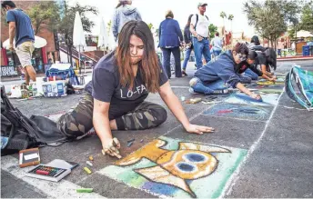  ??  ?? Acacia Raley, 19, Phoenix, a student at Arizona State University, tries her hand at sidewalk chalk painting at the Tempe Festival of the Arts, Friday, December 1, 2017.