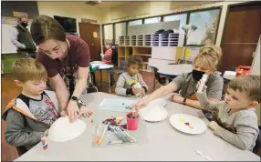  ?? NWA Democrat-Gazette/David Gottschalk ?? Kindergart­ner Lucas Sanders (from left), Danica Reed, paraprofes­sional, Mia Williams, a kindergart­ner, Amissa Dupont, specialist teacher, and Jaxon McCaslin, a kindergart­ner, work on an art project on Jan. 8 at Hope Academy of Northwest Arkansas in Highfill.