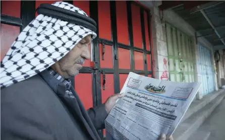  ?? — AFP ?? A Palestinia­n man reads a newspaper with a headline condemning US President Donald Trump’s decision to recognise Jerusalem as the capital of Israel.