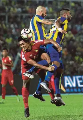  ?? PIC BY FARIZUL HAFIZ AWANG ?? Negri Sembilan’s Annas Rahmat (left) fights for the ball with Pahang’s Matheus Alves (right) and Kiko Insa at the Darulmakmu­r Stadium on Sunday.