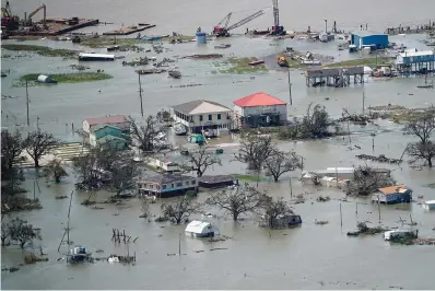  ?? The Associated Press ?? ■ Buildings and homes are flooded in the aftermath of Hurricane Laura on Aug. 27, 2020, near Lake Charles, La. In the past year, the southweste­rn Louisiana city of Lake Charles weathered two hurricanes, intense rainfall that sent water gushing down streets and a deep freeze that burst pipes. Under a revamped federal flood insurance program rolled out in the fall of 2021, millions of homeowners are set for rate hikes that officials say more accurately reflect a property’s risk.